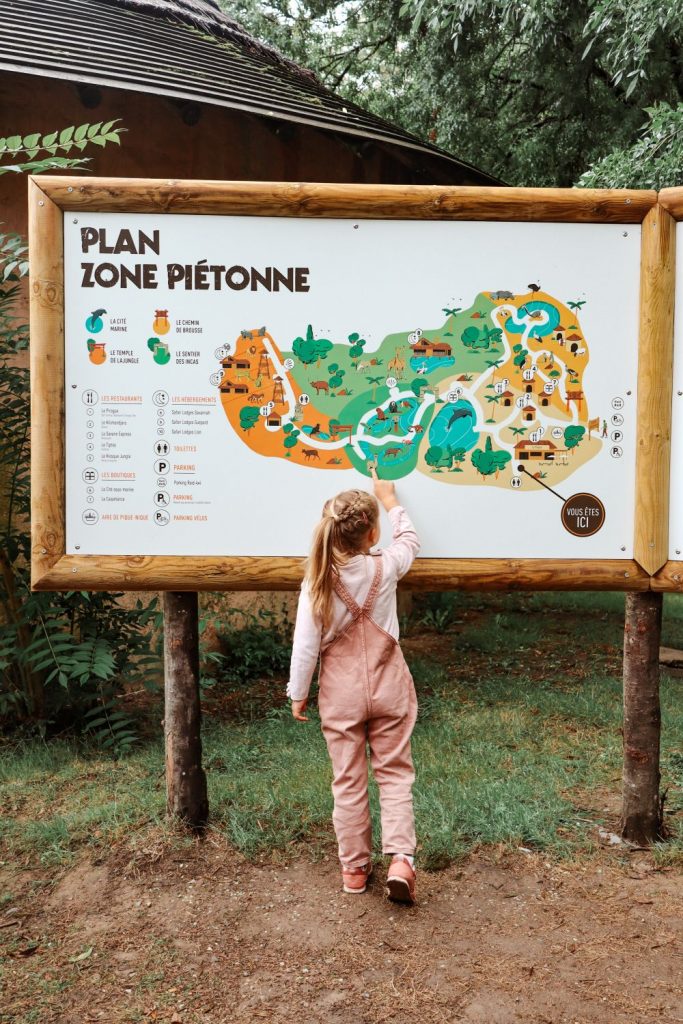 Billie die tijdens onze vakantie in de Loire voor een bord met illustratie van de wandelroute staat in Planète Sauvage.