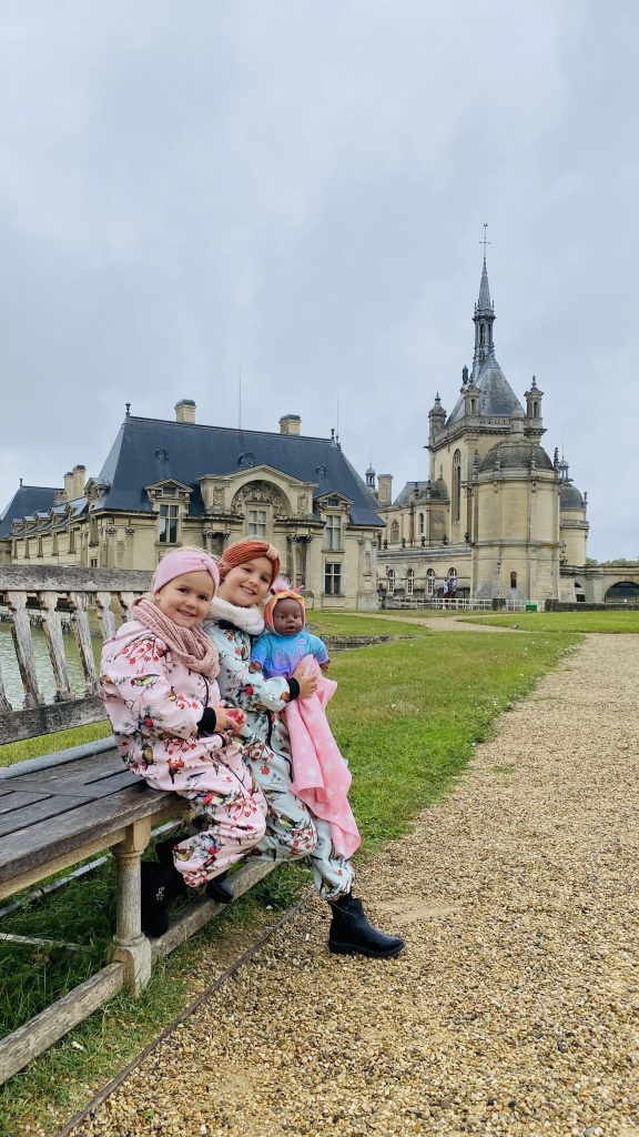 Noa en Billie op een bankje met het kasteel van Chantilly op de achtergrond tijdens ons weekend in Chantilly.